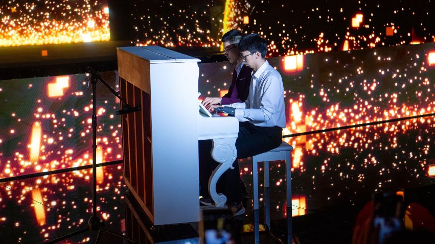 智能仿生手使用者古月與少年鋼琴家舒海峰合奏。主辦方供圖