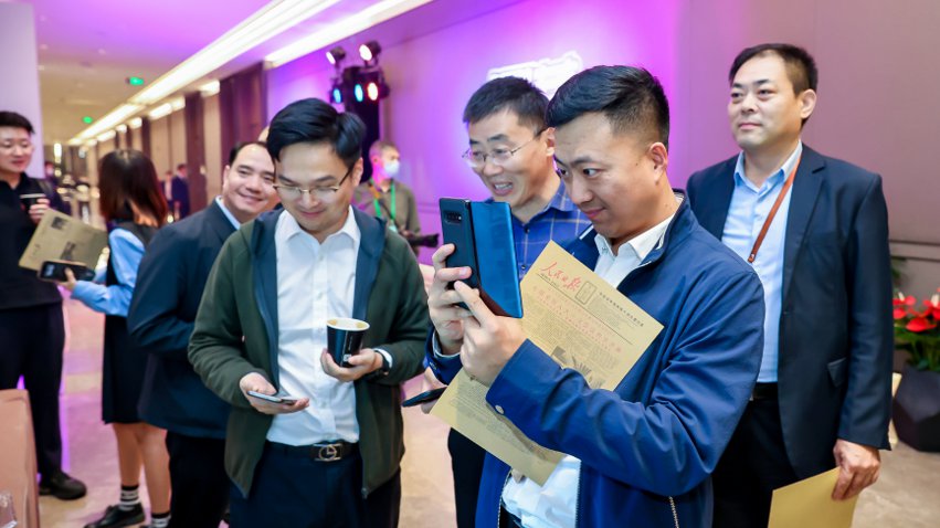 人民網(wǎng)研發(fā)推出的《人民日報(bào)》生日報(bào)吸引嘉賓體驗(yàn)。主辦方供圖