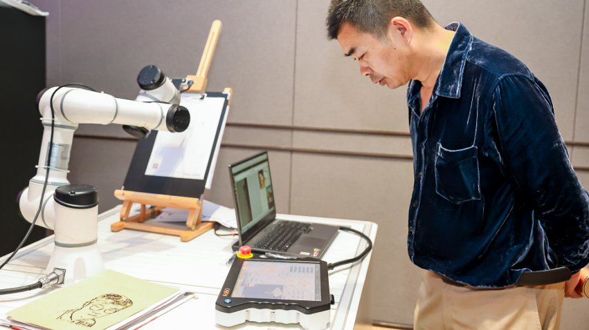 嘉賓體驗(yàn)遨博AI繪畫(huà)機(jī)器人。主辦方供圖